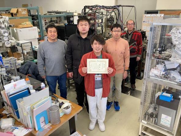 梅﨑智暉君（M2）の原子衝突学会第46回年会でのホットトピック講演の賞状とIOP出版東京事務所から副賞が届いたので、みんなで記念写真を取りました！